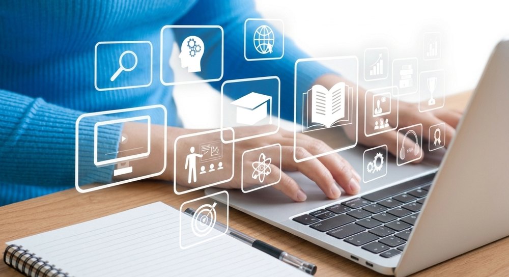 Person typing on a laptop with floating education icons such as a graduation cap, book and classroom